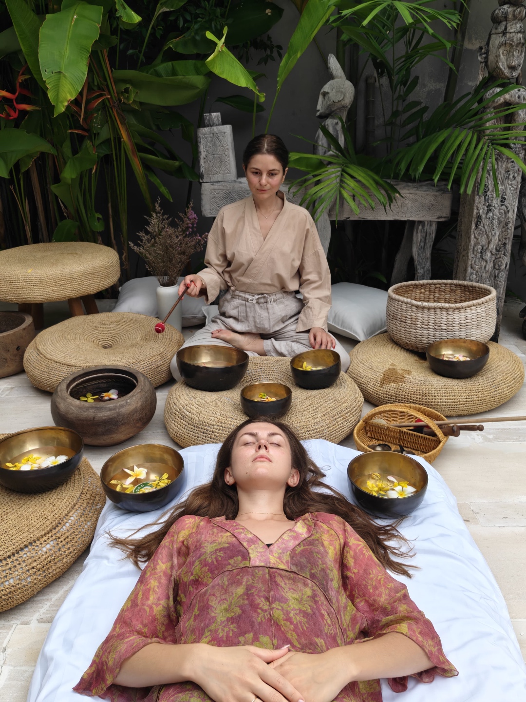 A client resting peacefully with eyes closed during a private sound healing session, surrounded by Tibetan singing bowls at Kate Sound Studio