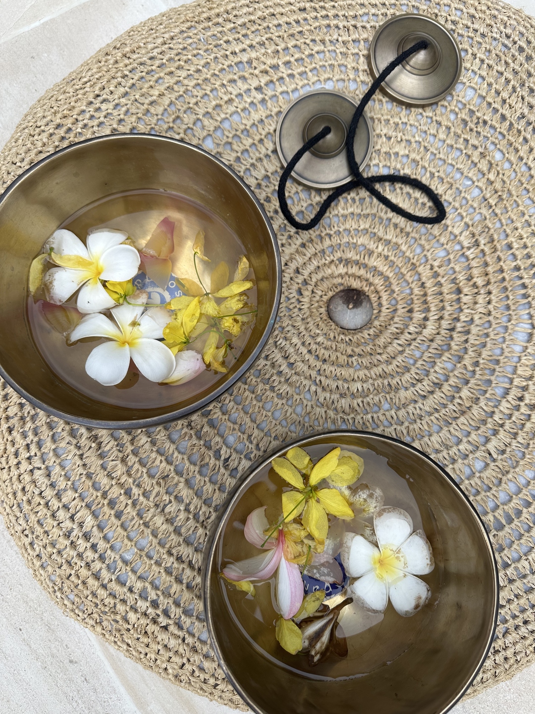 Tibetan singing bowls filled with tropical flowers, used during a sound healing session at Kate Sound Studio in Hong Kong
