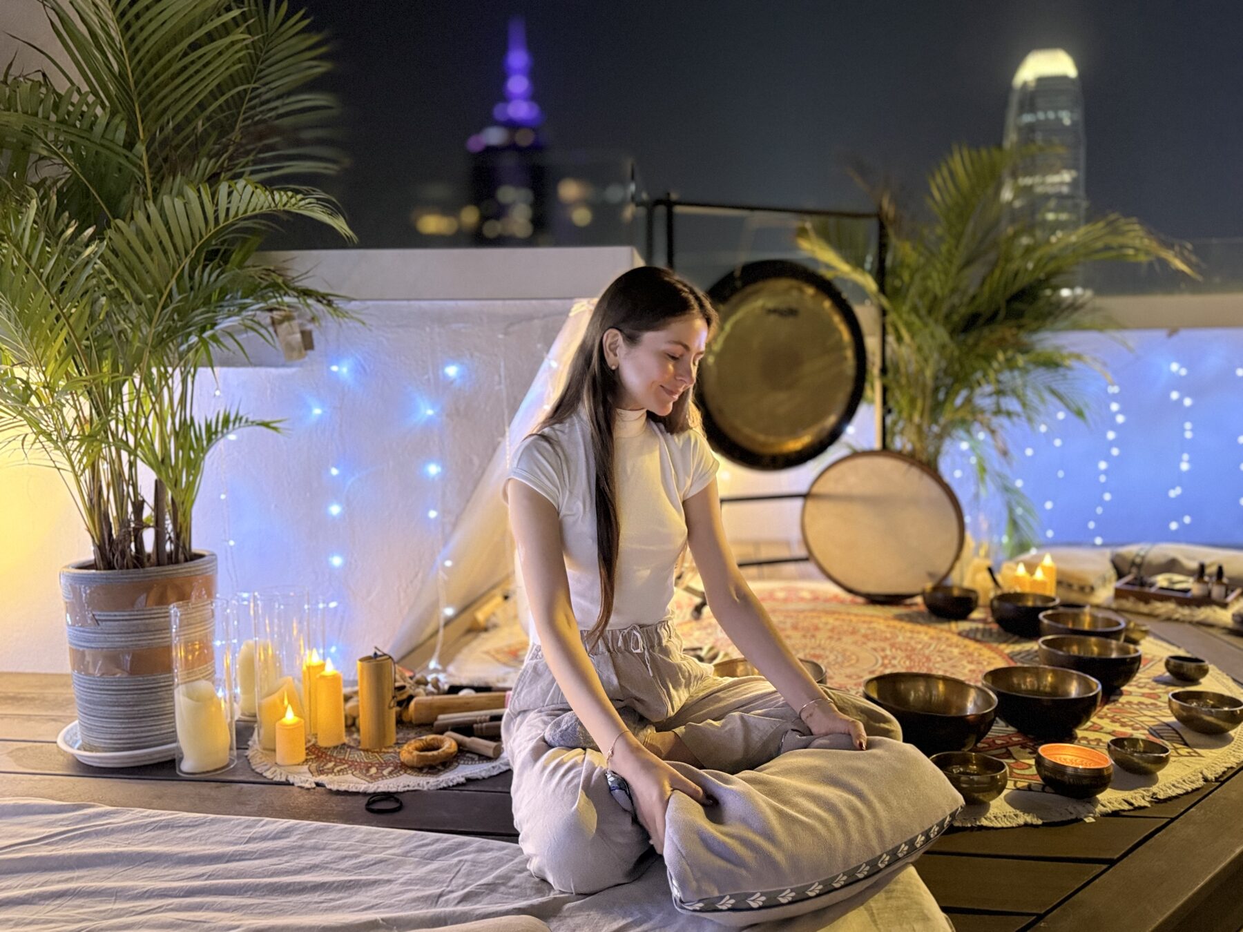 Kate facilitating a private rooftop sound bath session at dusk